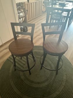 2 wooden seated steel swivel barstools