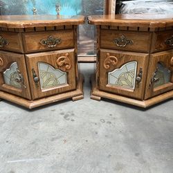 pair of oak end tables with a drawer and a cabinet featuring a stained-glass-style panel