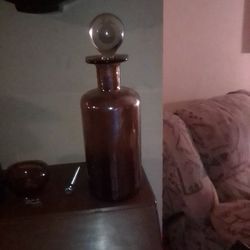 Heavy. See. Thru. Bottle. With. A. Brownish. Color. With. A. Round. Top