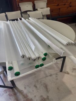12- 4 ft fluorescent light fixtures w/lenses and some bulbs
