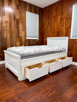 White twin bed with mattress and drawers