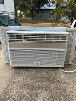 GE electronic window air conditioner with a white louvered front panel and a metallic control