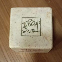 beige colored stone friendship cube with red, black and brown engravings