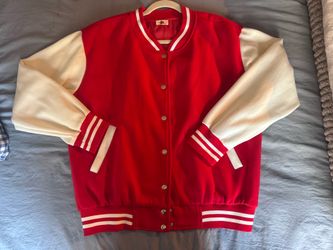 red varsity jacket with cream sleeves and striped ribbed trim