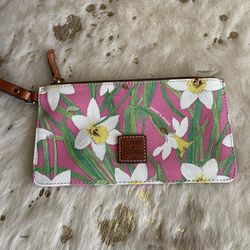 Perfect for Spring!  Dooney & Bourke coated canvas wristlet in pink and white daffodil print with leather strap and logo square.  Excelled pre-owned c