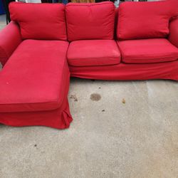 Red Ikea Couch Has Some Fading On The Sides From The Sun.