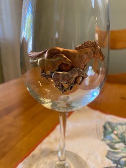 Wine glass with 3 d metal horses emblem . Good condition. Southwest/ cottage.