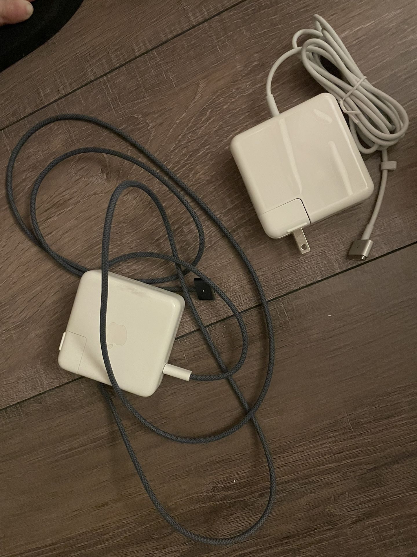 Two MacBook chargers with white and green wire