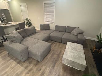 Modern gray sectional sofa with coffee table and bar stools