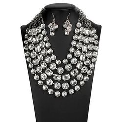 Featuring round and emerald style cuts, row after row of dramatically oversized white rhinestones delicately link into blinding layers below the colla
