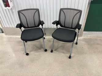 Two Global Roma Nester mesh back chairs- featuring a flip-up seat and silver casters.