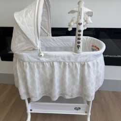 Delta Children Smooth Glide Bedside Bassinet - Portable Crib with Activity Mobile Arm Featuring Spinning Toys, Nightlight and Music