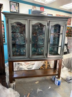 Custom finish tall cabinet with glass shelves and light