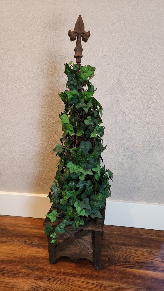 Silk ivy topiary in wood container with fleur de lis on top of metal pole