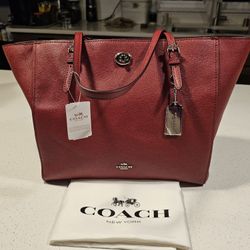 COACH burgundy leather tope with silver hardware.