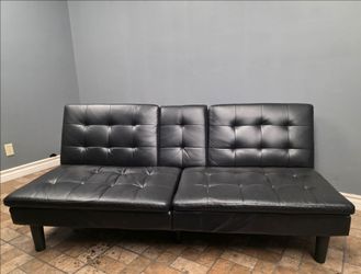 Black faux leather convertible futon / sofa bed with tufted cushions and split-back design Used