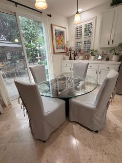 Round glass-top dining table with 4 chairs