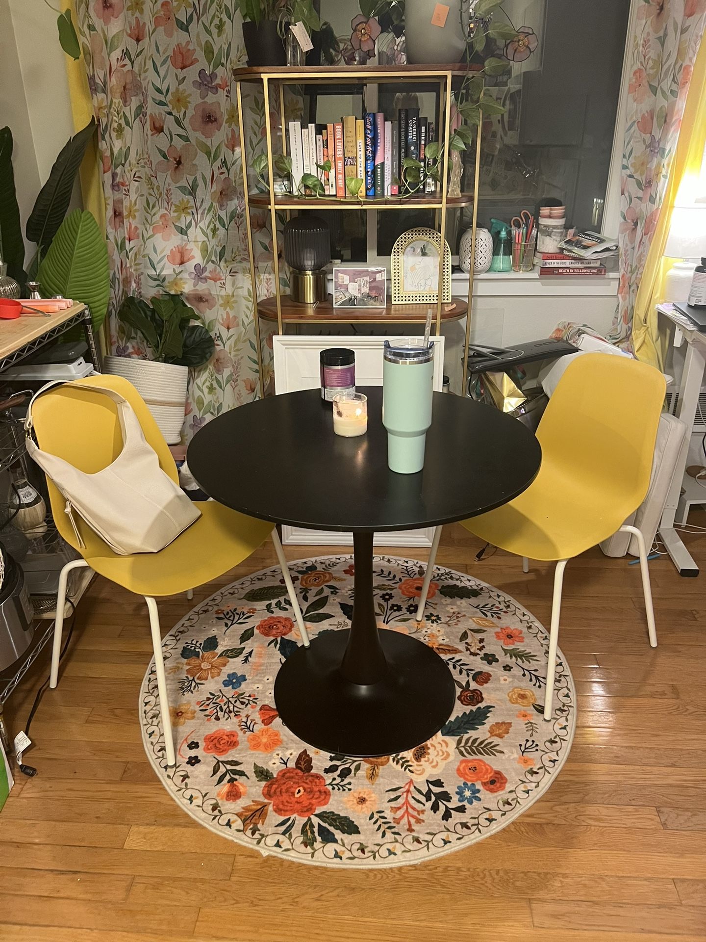 Black Bistro Table & Yellow Chairs & Floral Rug