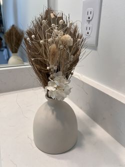 Dried floral arrangement in a neutral ceramic vase