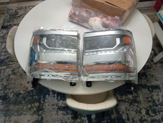 headlight assemblies for a 2016-2018 Chevrolet Silverado 1500.They feature a chrome housing bezel and integrated amber turn signal reflectors.The unit