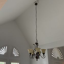 Beautiful chandelier with ornate design and frosted glass shades.