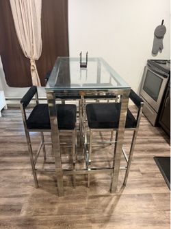 High top glass table and black suede and silver chairs