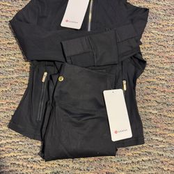 Lululemon matching navy blue/gold jacket and leggings set.