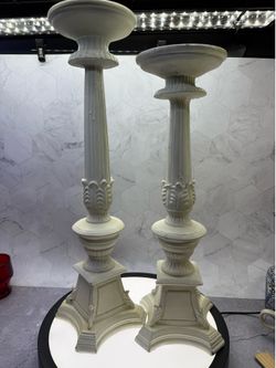 Set of (2) Vintage-style large polyrisen candlestick holders featuring a distressed off white finish. For indoor/Outdoor use. Great for photo shoots &