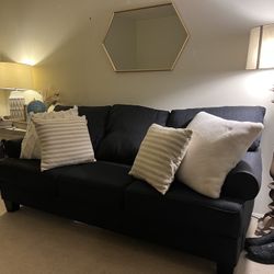 Navy blue couch and matching cushioned seat and ottoman