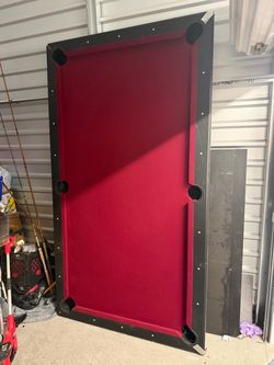 Selling a 8-foot pool table with red felt and black rails. NEEDS REPAIRS!!!