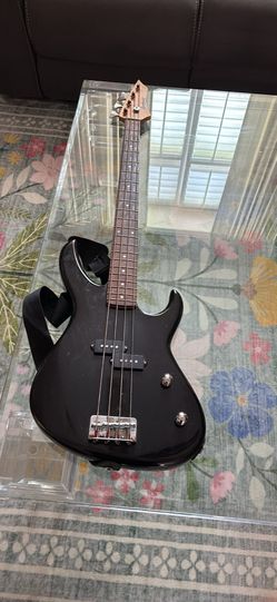 Sleek black Brownsville New York bass guitar. Has 4 strings. Comes with a strap.