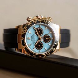 Rolex Cosmograph Daytona. This specific model features: 	•	A yellow gold case 	•	A striking “Tiffany blue”-like dial with 