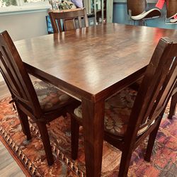 Brown wood table with four chairs/pads