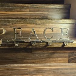 Shiny Golden Stocking Hangers Spelling Out "Peace"