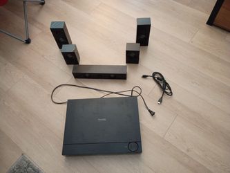 Samsung home theater Blu-ray player with sound system and speaker wiring.