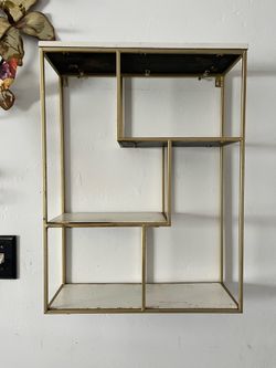 Gold metal wall shelf with staggered tiers