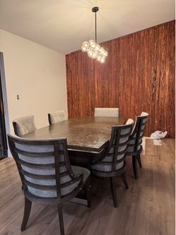 Grey wooden table with 6 grey upholstered chairs