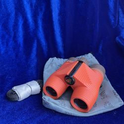 Nocs Provisions Standard Issue 8x25 Waterproof Binoculars featuring a vibrant orange rubber housing and a gray carrying pouch