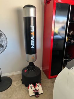Free standing punching bag with gloves and straps.