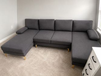 Gray fiber sectional sofa with gold legs.
