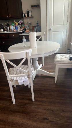 A white ROSENTORP round dining table with four legs, designed for easy extension.  play ROSENTORP Extendable table, white, 43 1/4/61 " ROSENTORP Exten