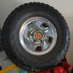 The tire is a Bridgestone Dueler A/T, an all-terrain tire designed for both on-road and off-road use. 
