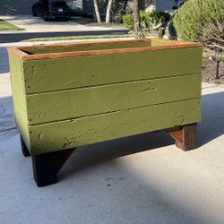 Raised Planter Box Painted Green With Light Wood Stained Trim And Accent Dark Stained Legs