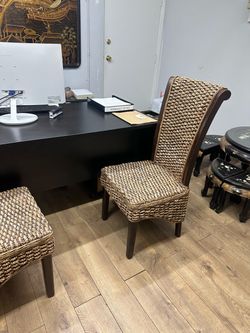 Two Elegant and unique chair featuring a rich dark wood frame and beautifully woven natural-tone seat and back. The detailed woven texture gives it a