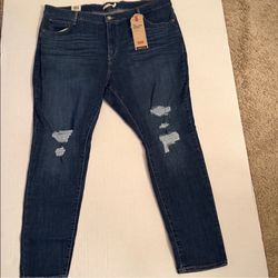 Levi's jeans with a dark blue wash. Features ripped details for a trendy look.
