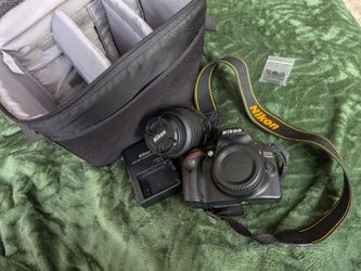 Nikon camera + lense + rechargeable battery and storage bag
