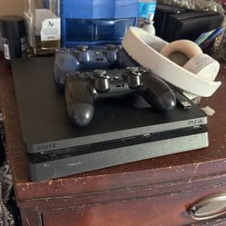 playstation 4 with 2 controllers and a wireless headset