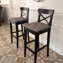 Bar stools with added cushions.