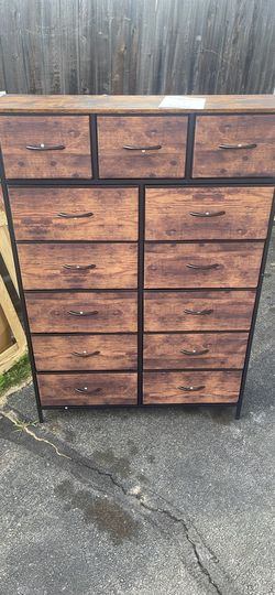 CAPHAUS dresser has thirteen fabric storage bins with a rustic oak wood-grain finish on the front panels