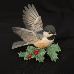 A Lenox porcelain chickadee figurine on a holly base.